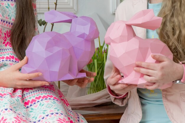 Children playing for Easter with rabbits of paper