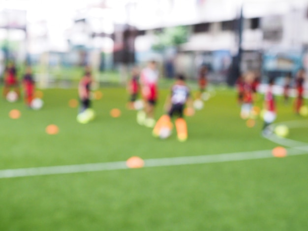 フィールドでサッカーを遊んでいる子供たち