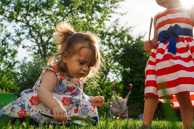 Photo children playing in the garden with magnifier