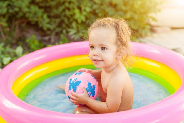 Bambini che giocano nella piscina gonfiabile per bambini.