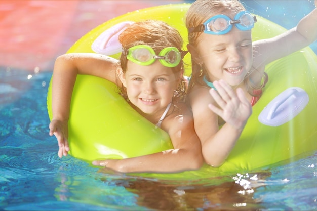 Children playing in pool. Two little girls having fun in the pool.