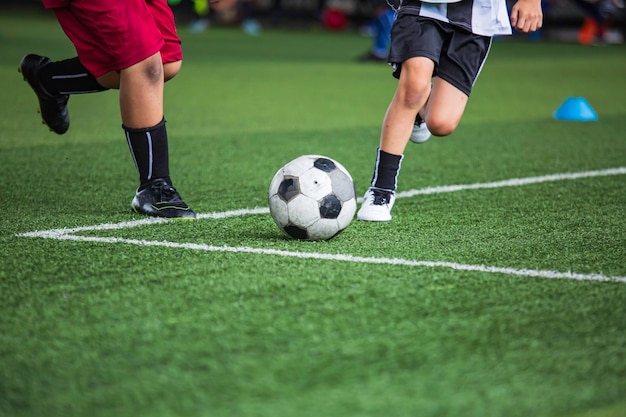 훈련 배경을 위해 잔디 필드에서 축구공 전술을 하는 어린이 축구에서 어린이 훈련