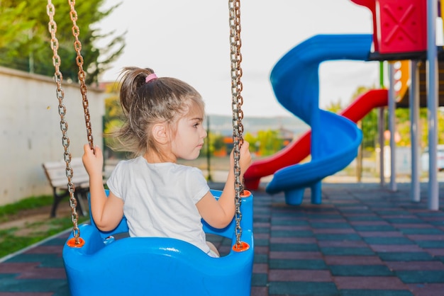 Children playing on swing in playground