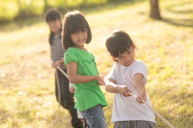 サンサットの公園で綱引きをしている子供たち