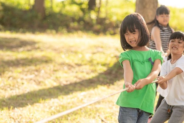 サンサットの公園で綱引きをしている子供たち