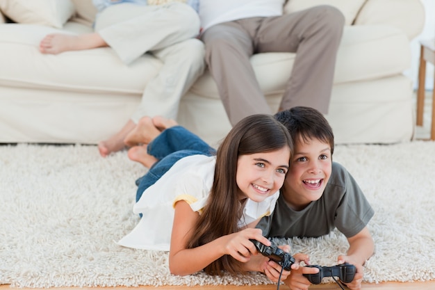 Children playing videogames while parents are talking 