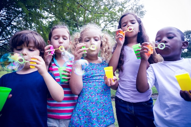 Photo children playing with bubble wand in the park