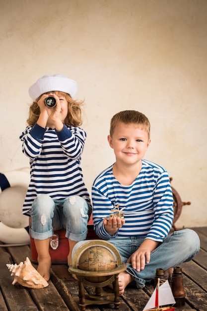 Children playing with vintage nautical things Kids having fun at home Travel and adventure concept Retro toned image