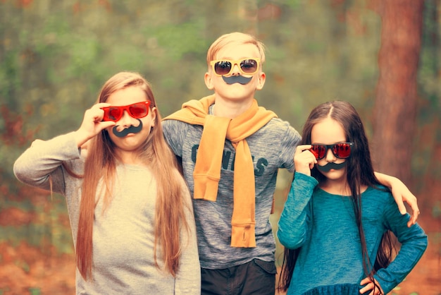 Children pose as adults with fake mustaches