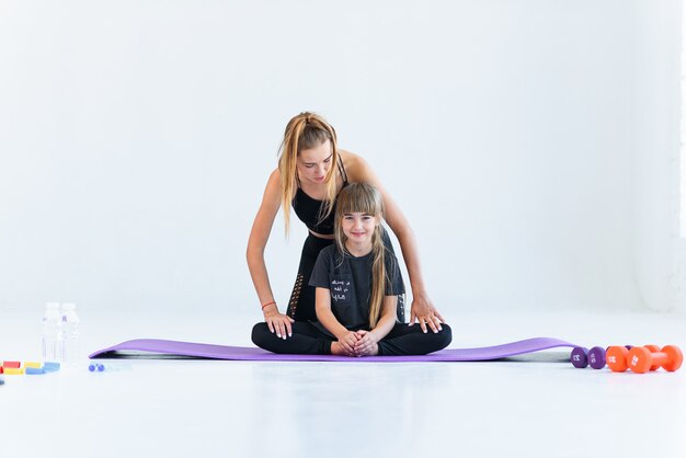 Children practicing are engaged in gymnastics and yoga with teacher