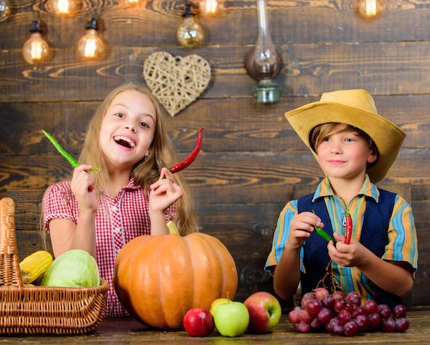 Children presenting farm harvest wooden background. Reasons why every child should experience farming. Farm market. Siblings having fun. Kids farmers girl boy vegetables harvest. Family farm.