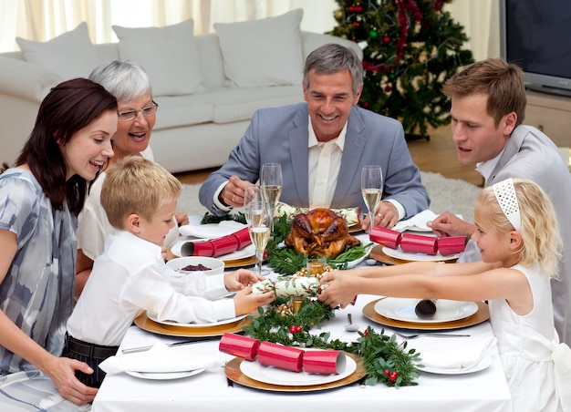 自宅でクリスマスクラッカーを引っ張っている子供たち