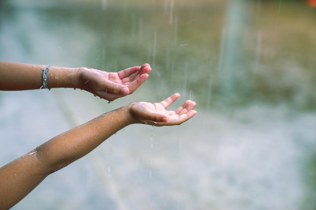 Children putting hands in the rain catching drops of rain 