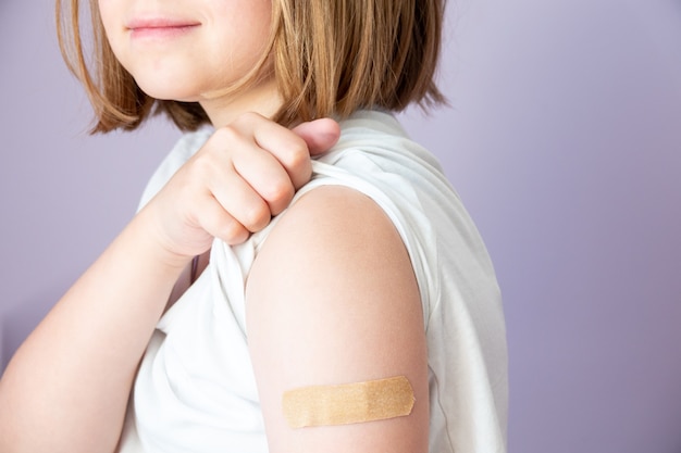 太ももの外側でワクチンを接種している子供。子供用ワクチン。 COVID