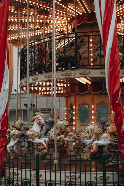 Photo children ride horses and teddy bear on childrens carousels in an amusement park