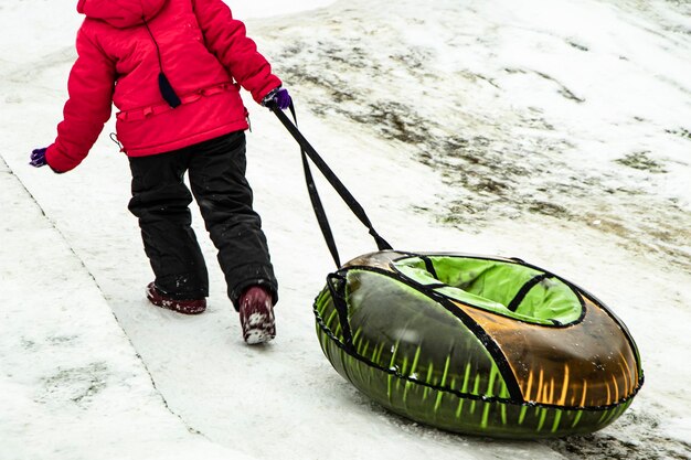 Children ride on a snow slide Games for children in snowy weather