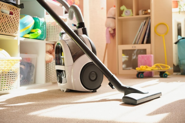 Детская комната после уборки пылесос в комнате девочки чистит ковер в детской