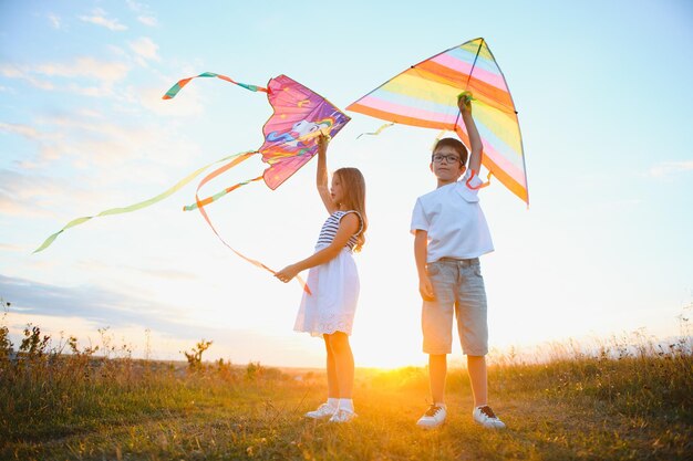 Children running with kite in the field