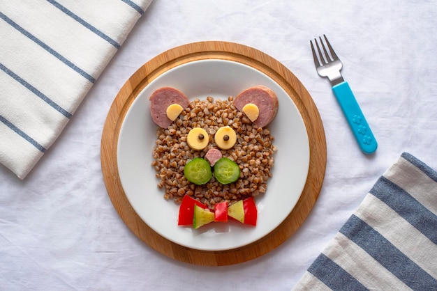 Children's breakfast Buckwheat porridge cheese and sausage in the form of a bear's muzzle