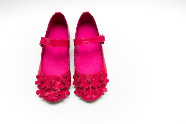 Children's bright pink shoes and scarf on a white background