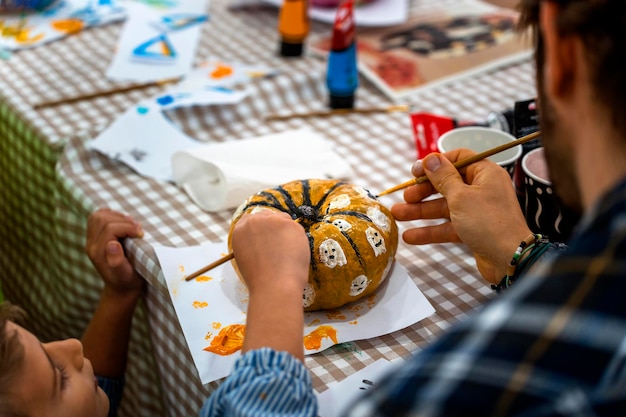 Children's drawing class Children painting pumpkins with their parents