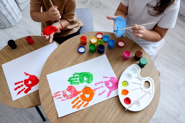 Children's drawing workshop happy children make handprints with paint