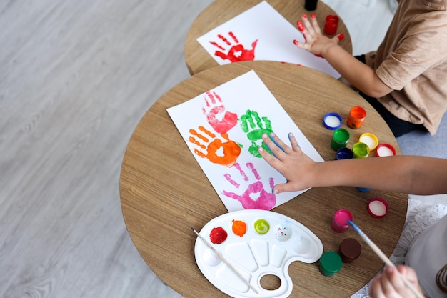 Children's drawing workshop happy children make handprints with paint