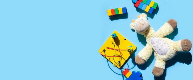Foto i giocattoli educativi per bambini sono sparsi su uno sfondo blu banner piatto con vista dall'alto