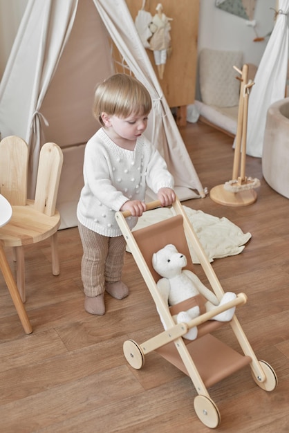 Children's educational wooden toys Nursery decor Scandinavian style playroom Wooden stroller Baby boy with wooden cart