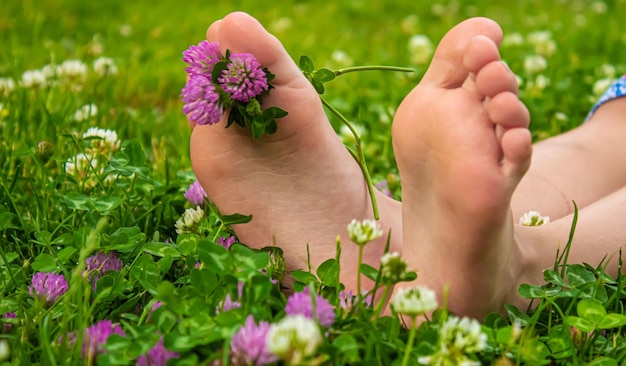 Children's feet with a pattern of paints smile on the green grass Selective focus