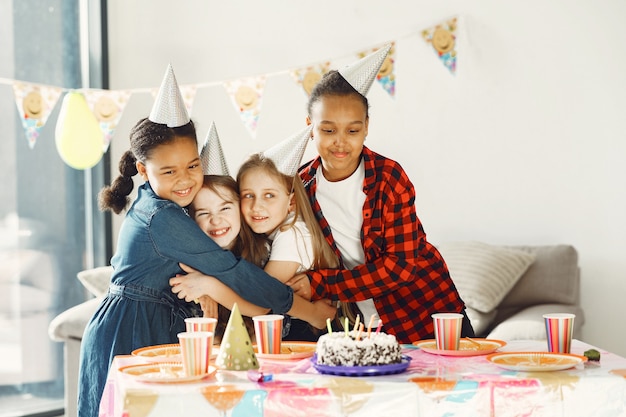 装飾された部屋での子供の面白い誕生日パーティー。ケーキと風船で幸せな子供たち。