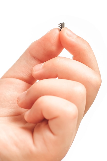Детская рука, держащая маленький черный чип изолирована