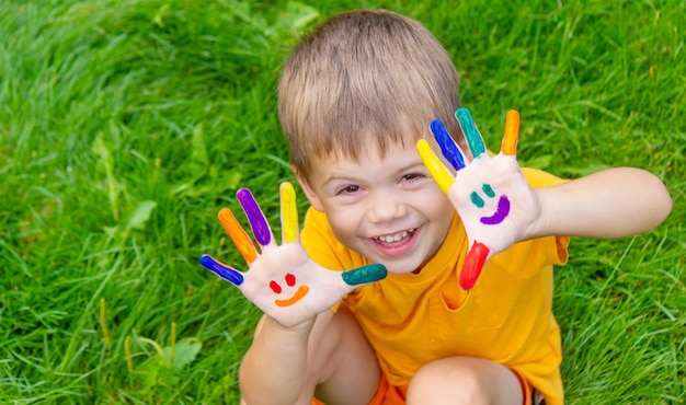 Children's hands in the colors of summer a smile on the boy's palm