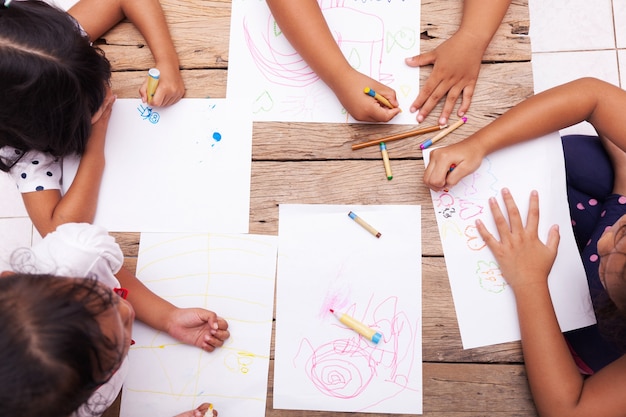 어린이 손 나무 테이블에 색연필으로 그리기