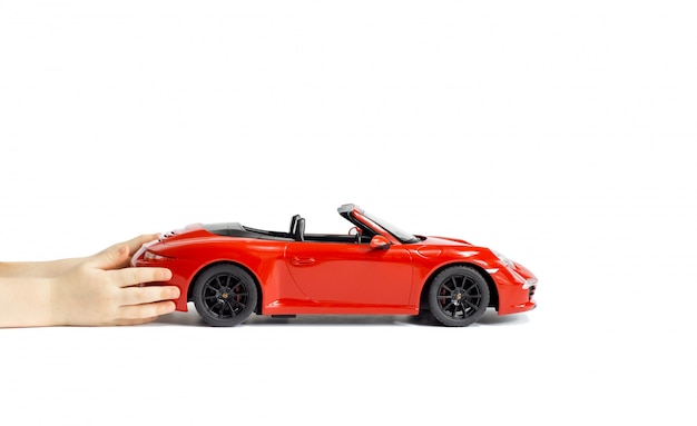 어린이 손에 들고 빨간색 포르쉐 카레라 S 911 모델 장난감 자동차 흰색 배경에 고립.