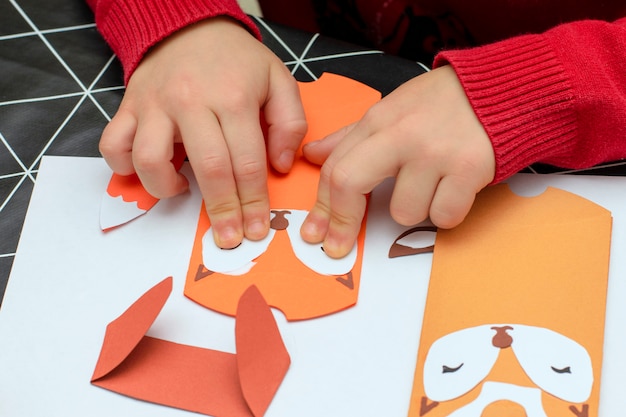 Children's hands make Christmas paper crafts