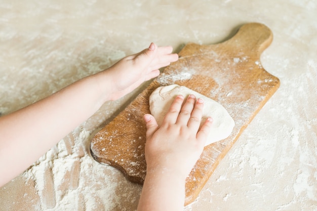 Children's hands make dough