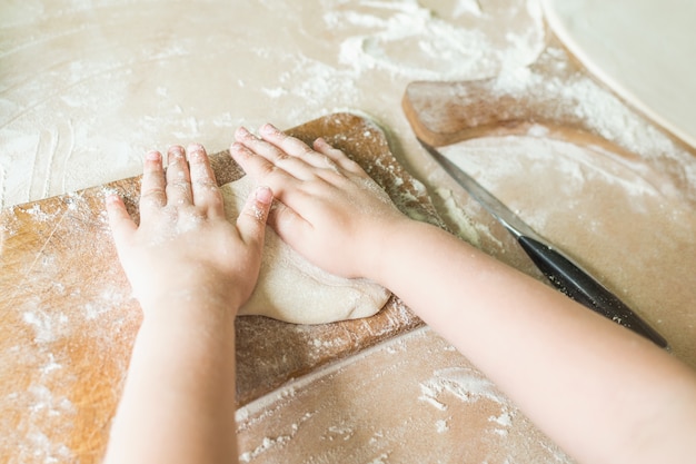 Children's hands make dough