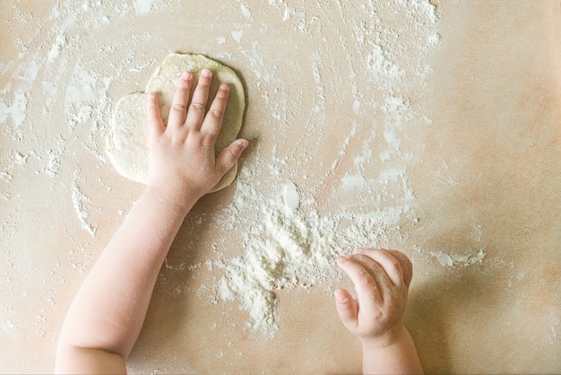 Children's hands make dough