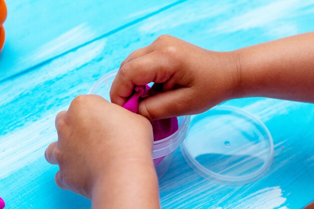 Children's hands mold colorful dough close-up. Childhood kids education concept