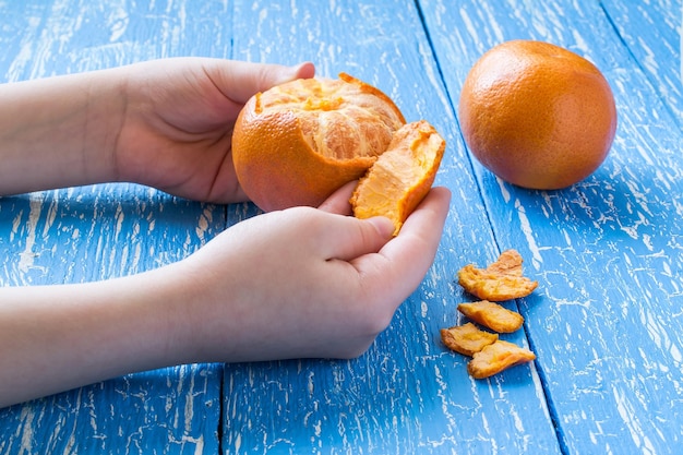 Фото Детские руки чистят мандарин