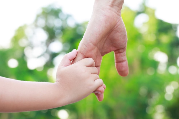 写真 母親のケアの温かさを持った子供の手