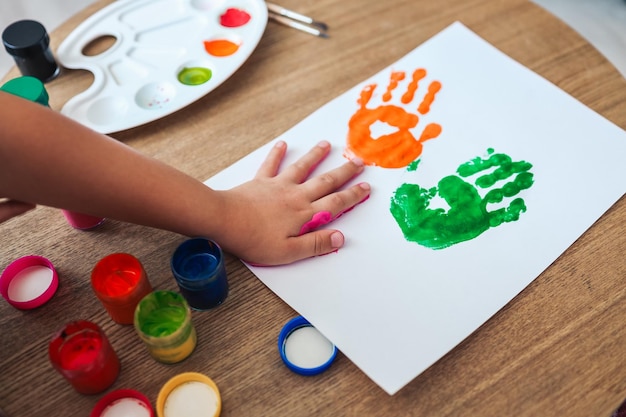 La master class per bambini nel disegnare il bambino fa un'impronta a mano con la vernice