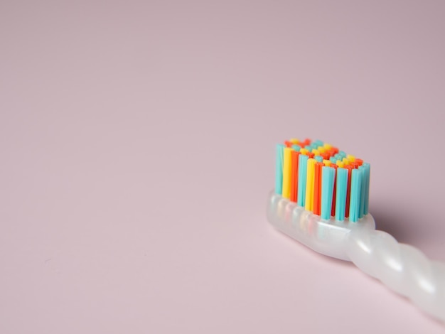 Children's multicolored tooth care brush on a purple background