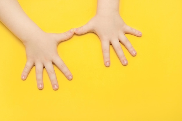 Photo children's palms on a yellow background with copy space