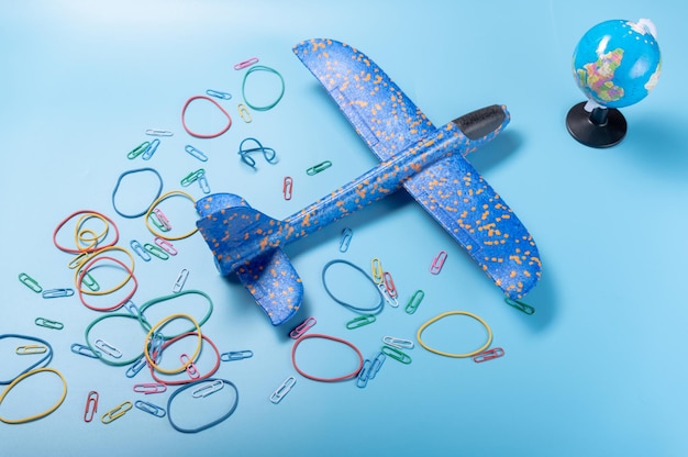 Photo children's plane and globe airplane on a blue background airplane flying around the earth view from above