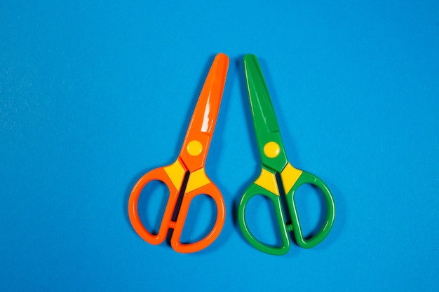 Фото Детские пластиковые ножницы для вырезания фигурок из бумаги на цветном фоне