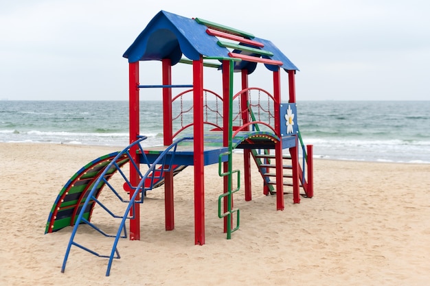 Детская игровая площадка для активных игр на пляже. Красочная пустая детская площадка в парке у моря. Благоустройство общественных пространств.