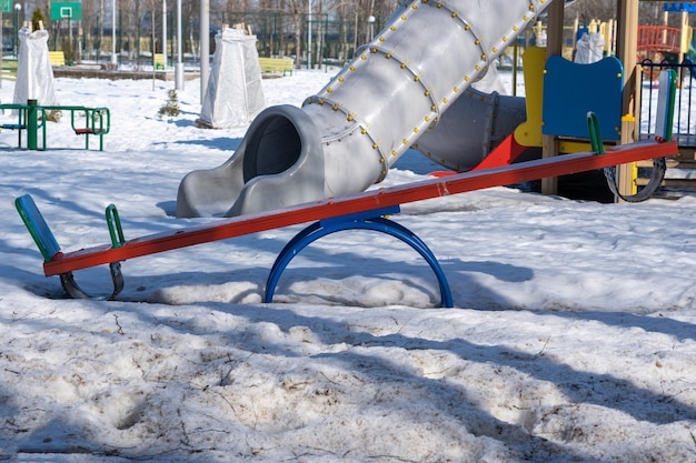 Foto parco giochi per bambini in inverno in russia, altalena in legno in primo piano