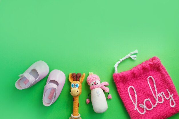 Children's shoes lie on a light green background top view. space for the text. baby slippers.